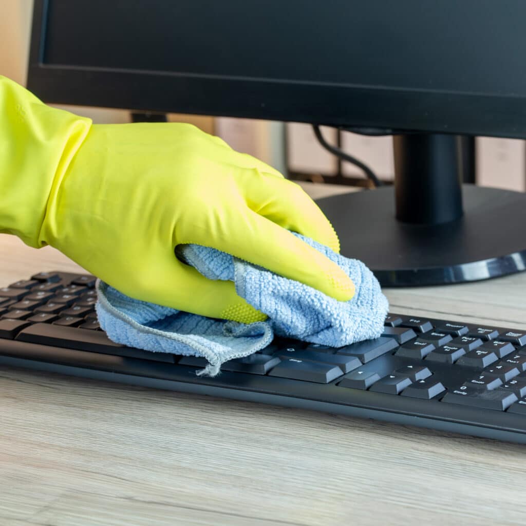 Büroreinigung: Nahaufnahme von der Reinigung eines Büroschreibtisches